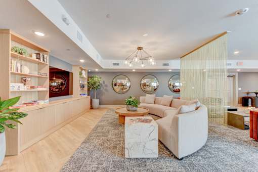 A living room with a white couch, a coffee table, and a bookshelf.