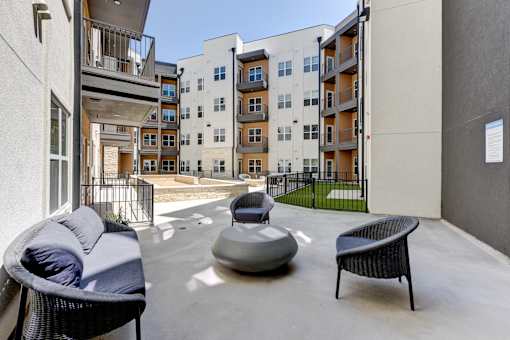 A patio with a chair, a couch and a table.