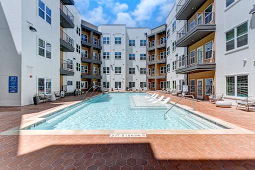A swimming pool in the middle of a courtyard surrounded by buildings.