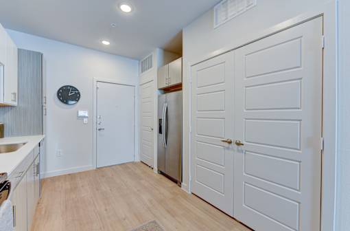 A kitchen with white cabinets and a clock on the wall.