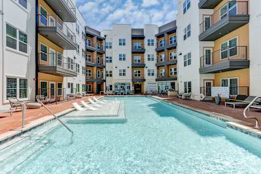 A swimming pool in front of apartment buildings.