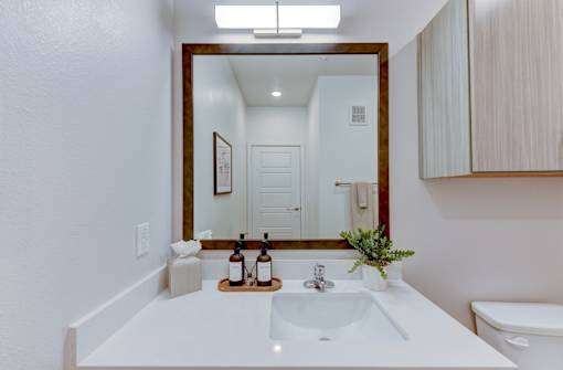 A white sink in a bathroom with a mirror above it.