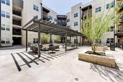 A courtyard with a tree and a bench.
