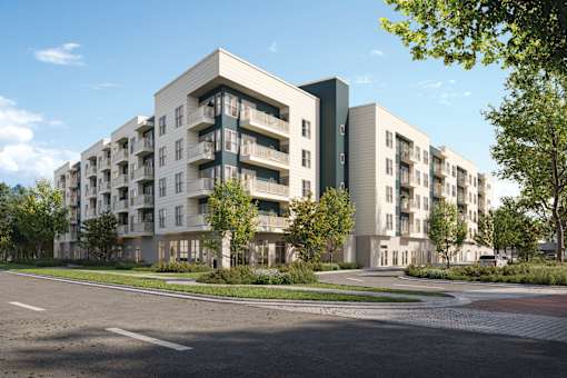 A modern apartment building with a parking lot in front.