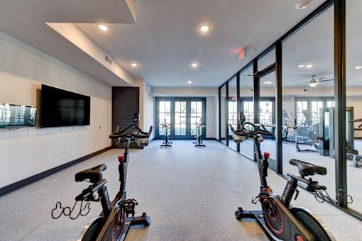 A spacious room with exercise bikes and a television.