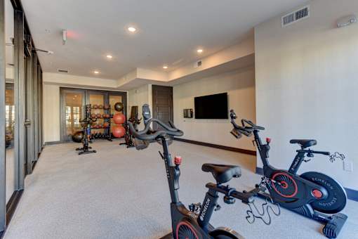 A room with exercise bikes and a television.
