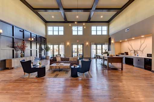 A spacious living room with a dark wood floor and furniture.