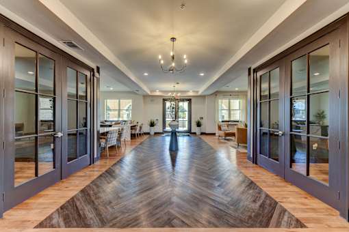 A long hallway with a wooden floor and glass doors on both sides.