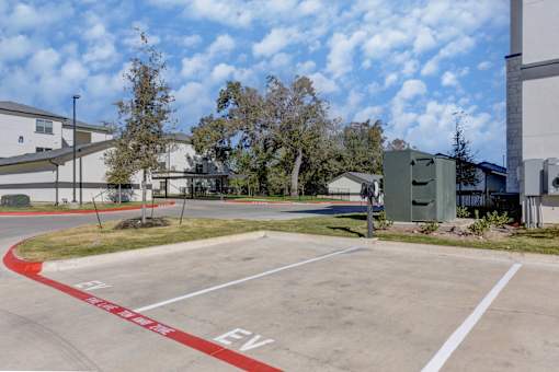 A parking lot with a red line on the ground and the letters "EV" painted on the pavement.