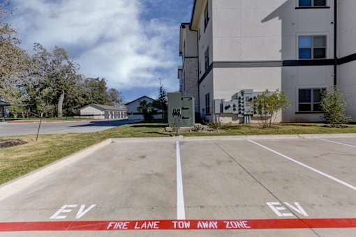 A parking lot with the words "EV" and "Fire Lane" painted on the pavement.