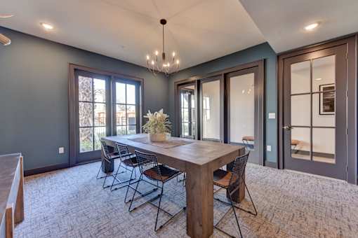 A dining room with a wooden table and chairs.