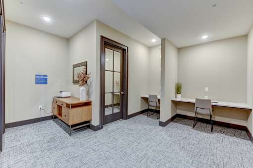 A room with a desk and chairs in it.
