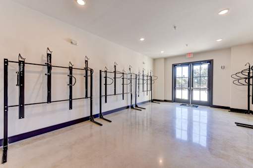 A gym with a row of black weight racks.