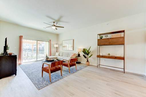 A living room with a wooden floor and a ceiling fan.