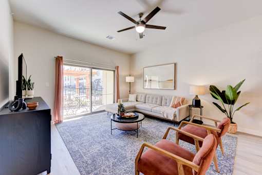A living room with a white couch, a coffee table, and a ceiling fan.