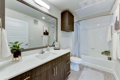 A modern bathroom with a white countertop and a white sink.