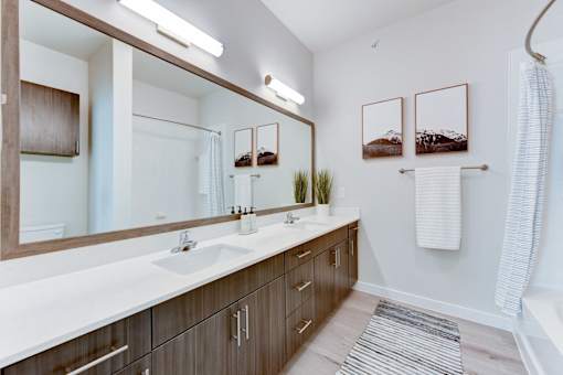 A bathroom with a white countertop and brown cabinets.