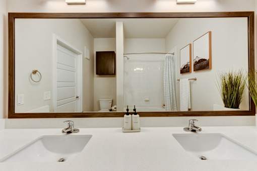 A bathroom with two sinks and a large mirror.