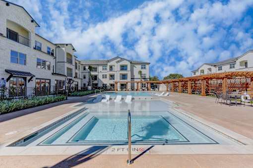 A swimming pool in front of a building with a sign that says 2 FT.
