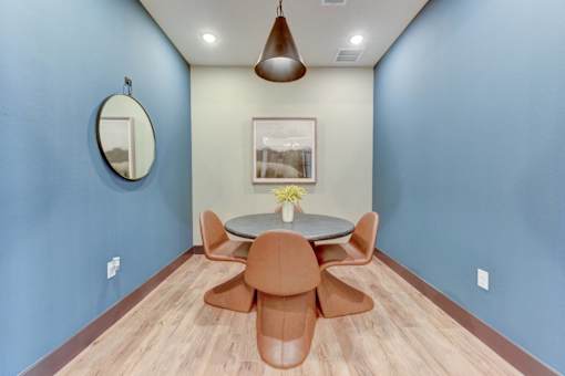 A blue room with a brown table and chairs.