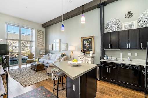 A kitchen with black cabinets and a white island.