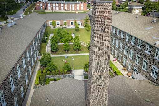A view of a campus with a building that says UNIVERSITY MILL.