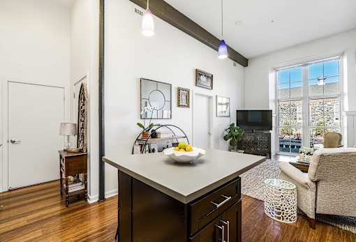 A modern kitchen with dark wood floors and white walls.