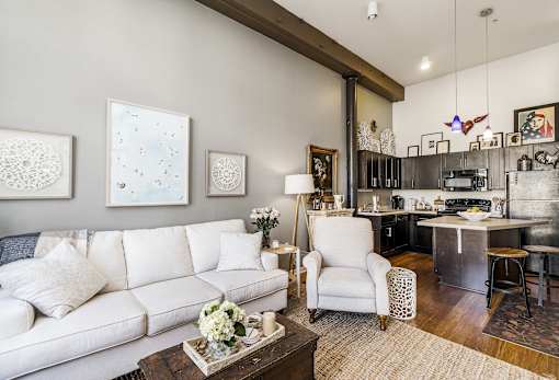 A living room with a white couch and a coffee table with flowers on it.