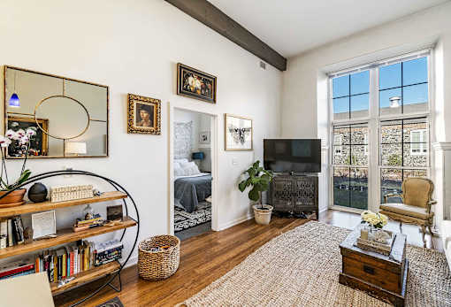 A living room with a large window and a flat screen TV.