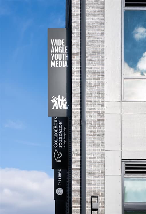 A tall building with a sign that says Wide Angle Youth Media.