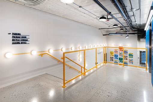A long hallway with orange railings and lights on them.