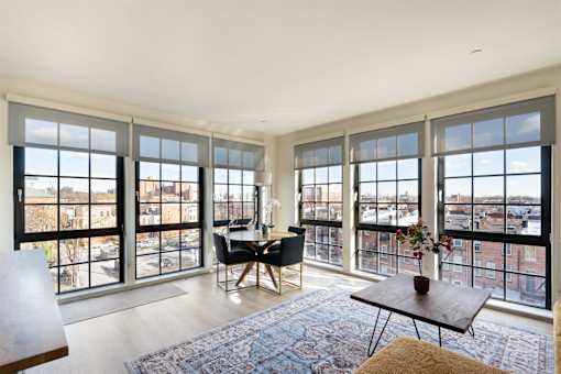 A living room with a view of the city through large windows.