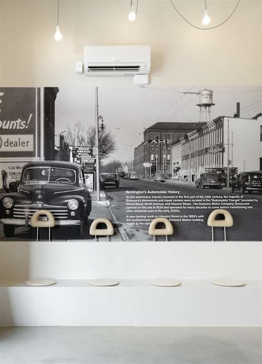 A black and white photo of an old car is displayed on a wall.