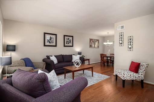 A living room with a purple couch and a wooden coffee table.