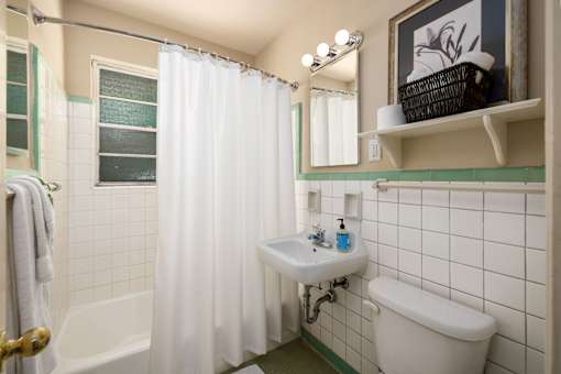 A bathroom with a white tub, sink, and toilet.