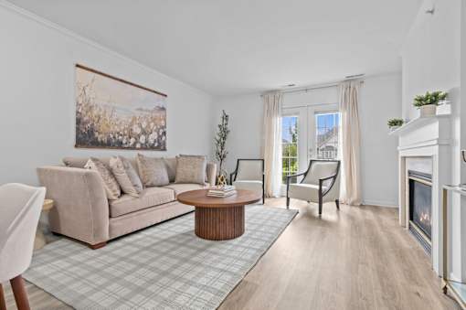 Bright living room with fireplace and hardwood floors at Regents Club of Troy Apartments, Troy