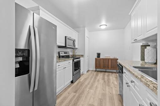 Modern galley kitchen with white cabinets at Regents Club of Troy Apartments, Troy, MI