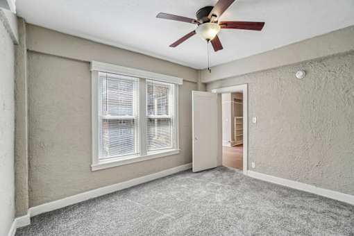 A room with a ceiling fan and a window.