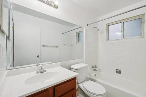 A white bathroom with a toilet, sink, and bathtub.