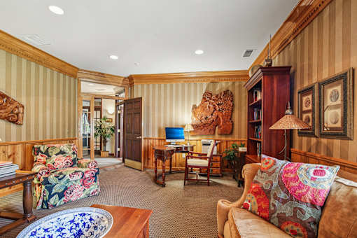 A living room with a couch, chair, and a table with a lamp.