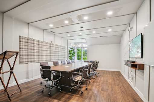 A conference room with a long table and chairs.