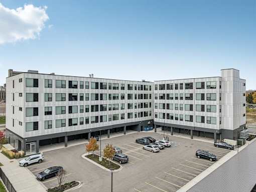 A large white building with a parking lot in front.