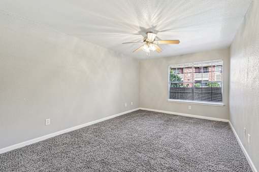A room with a ceiling fan and a window.