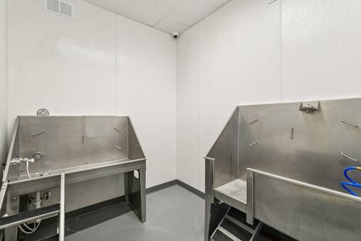 Two stainless steel sinks in a white room.
