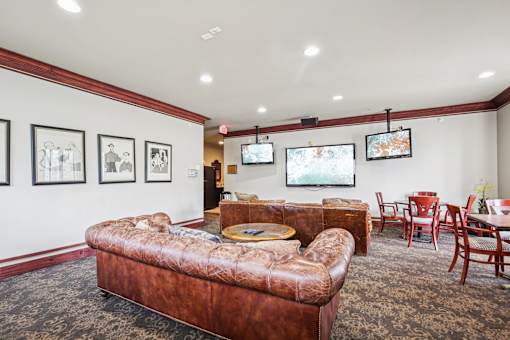 A living room with a brown leather couch and a coffee table.