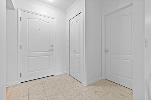 Tiled entryway with white doors and crown molding at Regents Club of Troy Apartments, Troy, MI