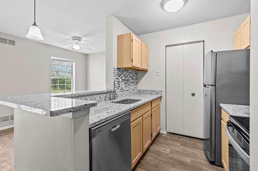 A kitchen with a black dishwasher and a white refrigerator.