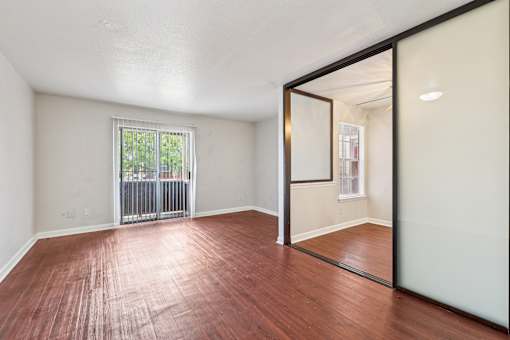A room with a wooden floor and a sliding glass door.