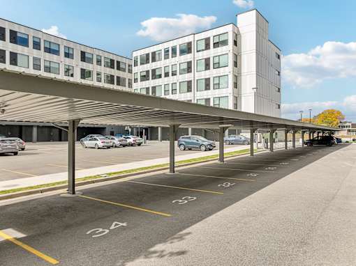 A parking lot with cars parked and a building in the background.
