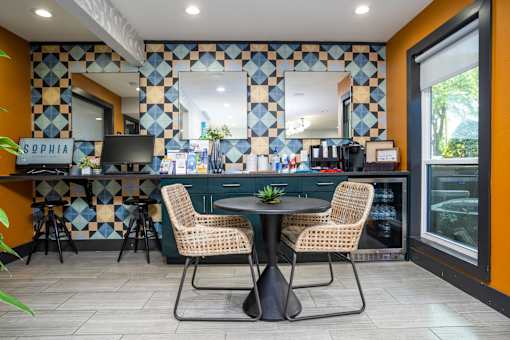 A kitchen with a table and chairs in front of a tiled wall.